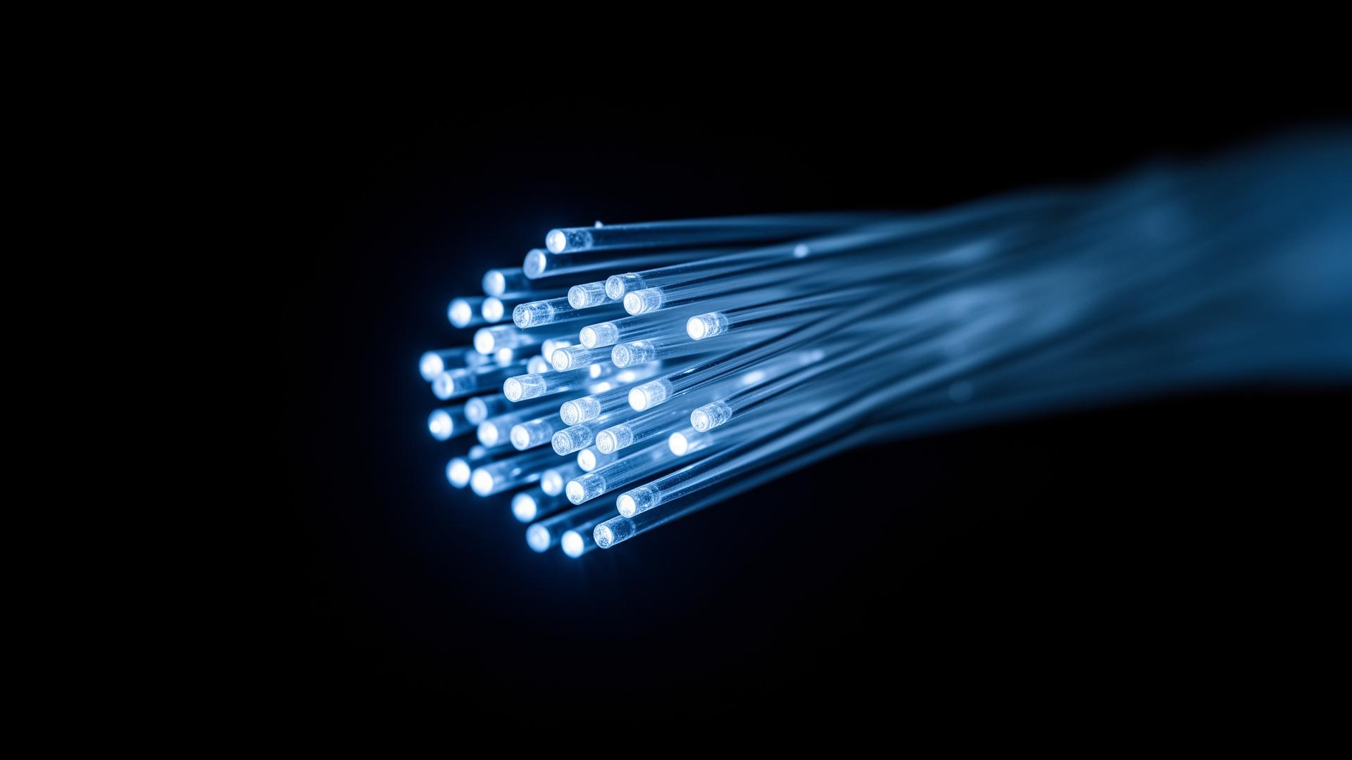 Macro photograph of a glowing fiber-optic bundle representing always-on market data.
